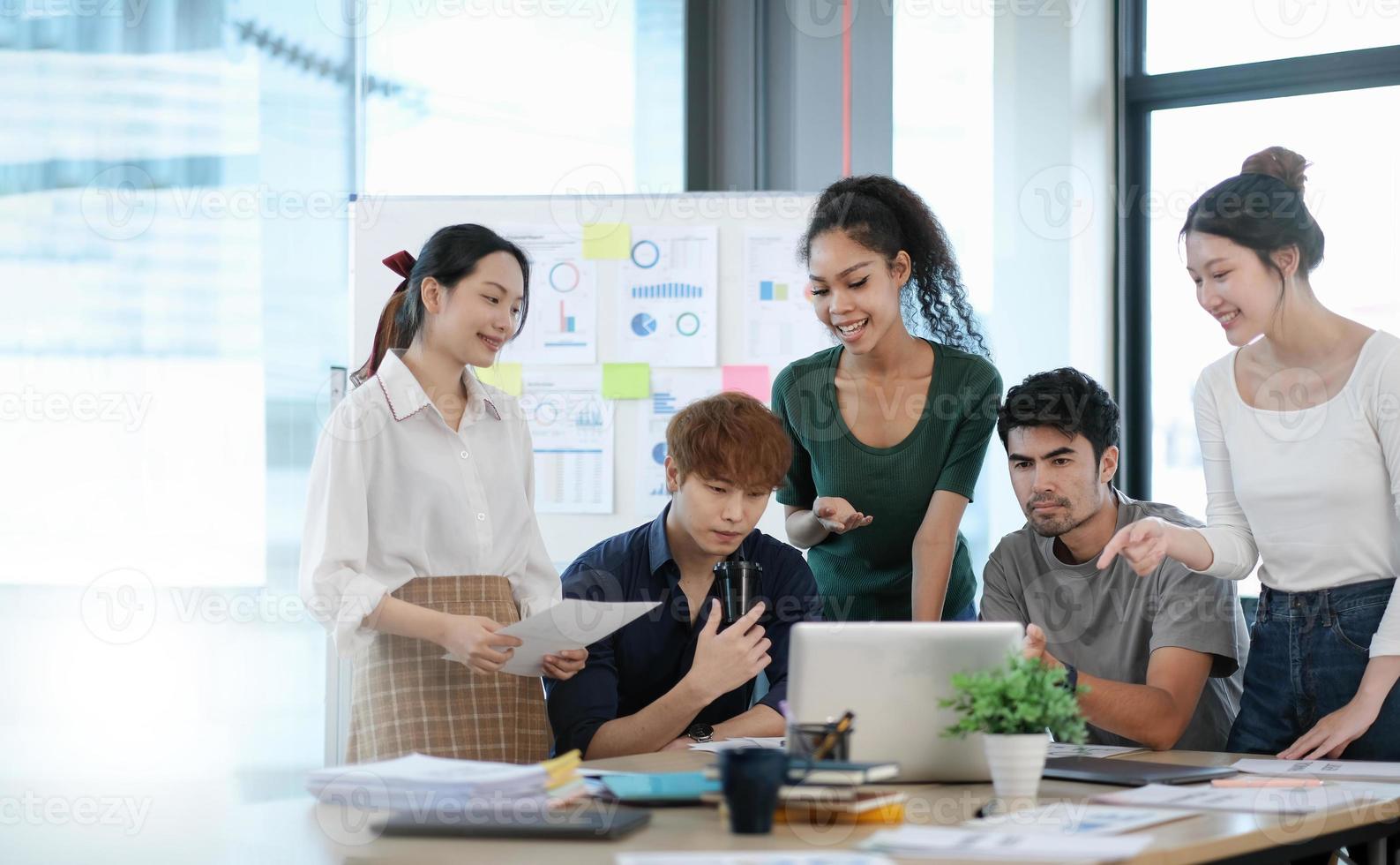 grupo de negocios asiáticos reunidos y discutiendo con un nuevo proyecto de idea de inicio. gente de negocios creativa que planifica el análisis de la estrategia y la lluvia de ideas con el informe del documento en la oficina foto