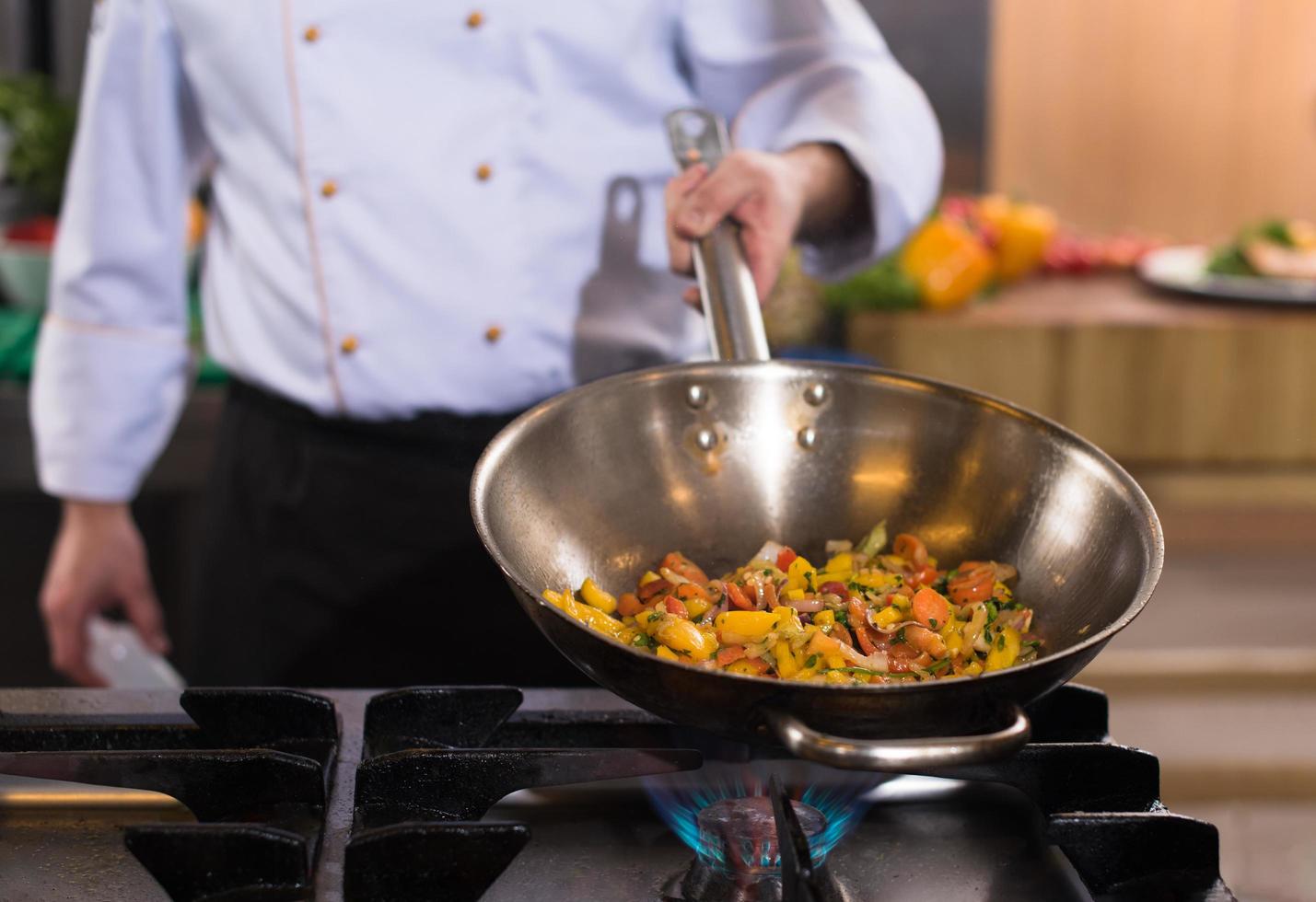 chef flipping vegetables in wok photo