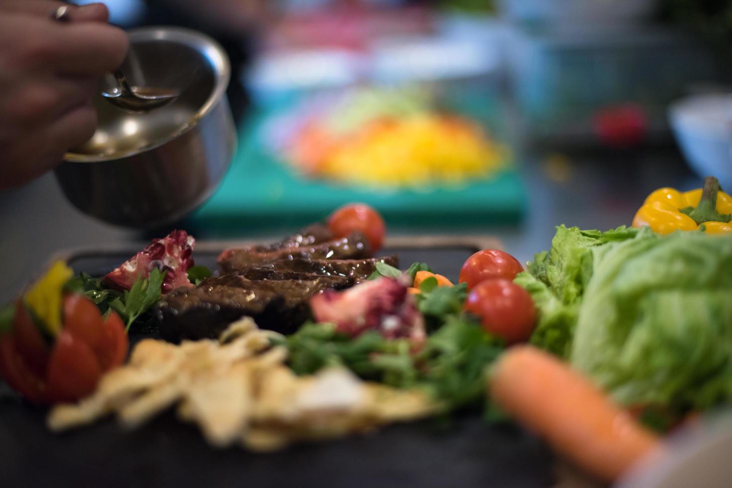 Chef hand finishing steak meat plate photo