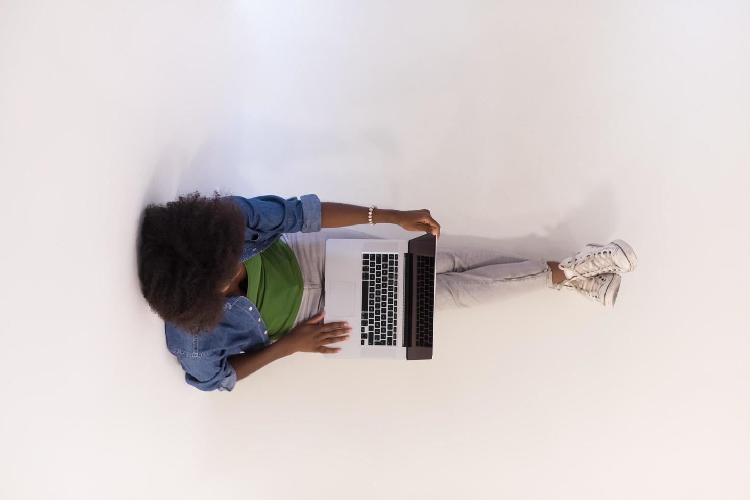 african american woman sitting on floor with laptop top view photo