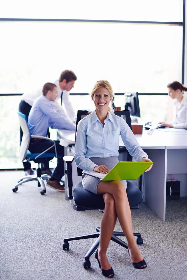 business woman with her staff in background at office photo