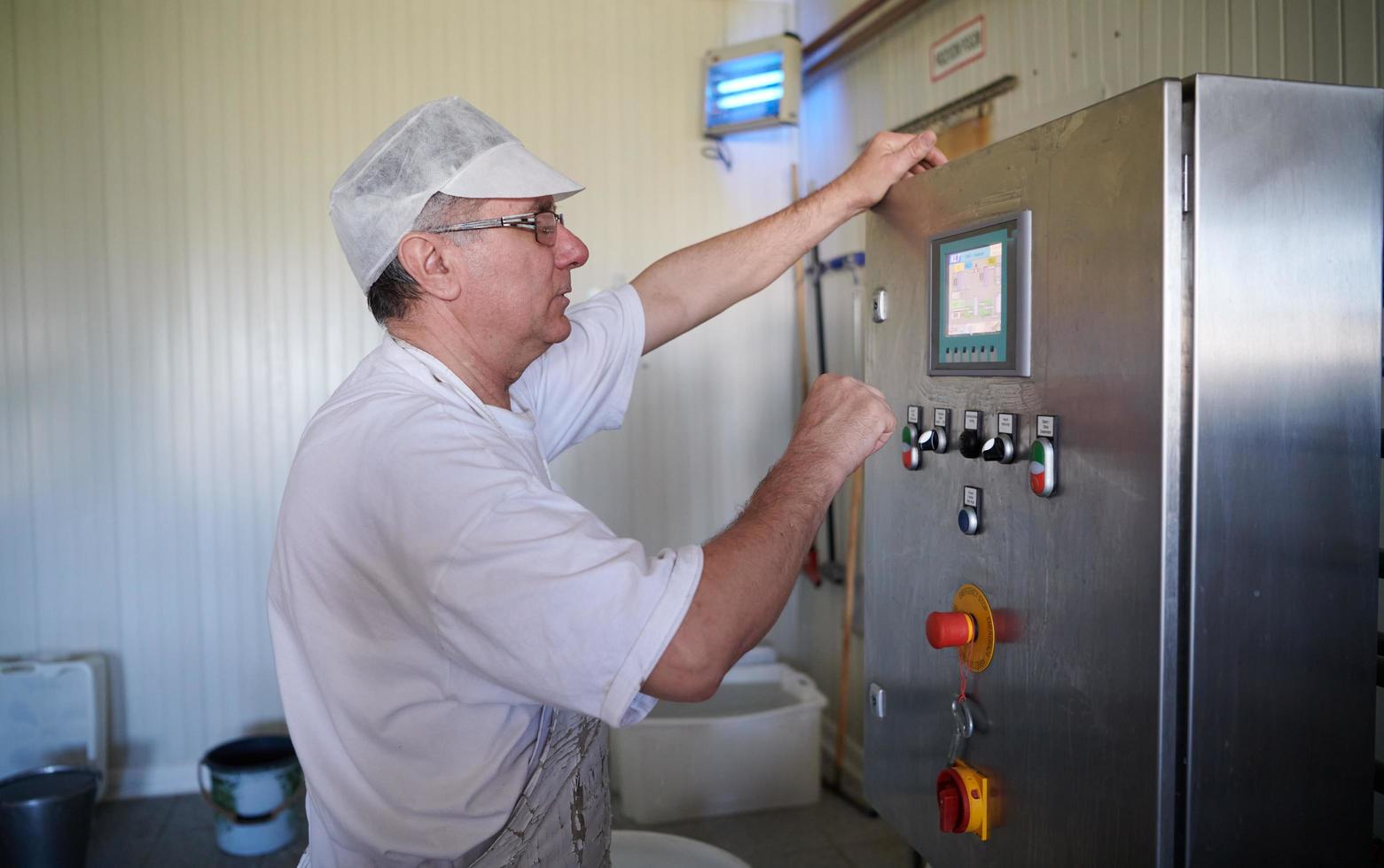 Cheese production cheesemaker  working in factory photo