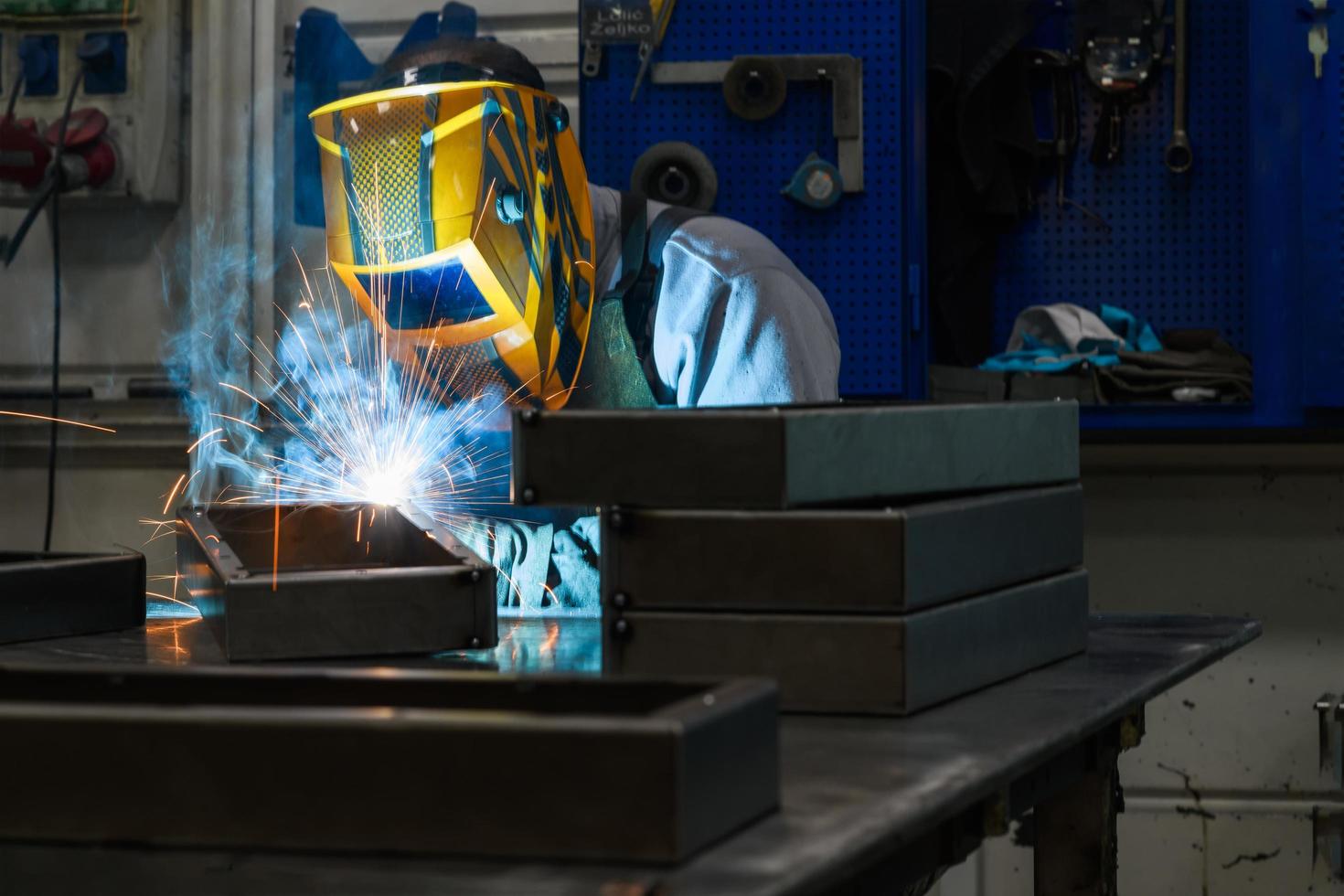 Professional welder performs work with metal parts in factory, sparks and electricity. Industry worker banner. photo