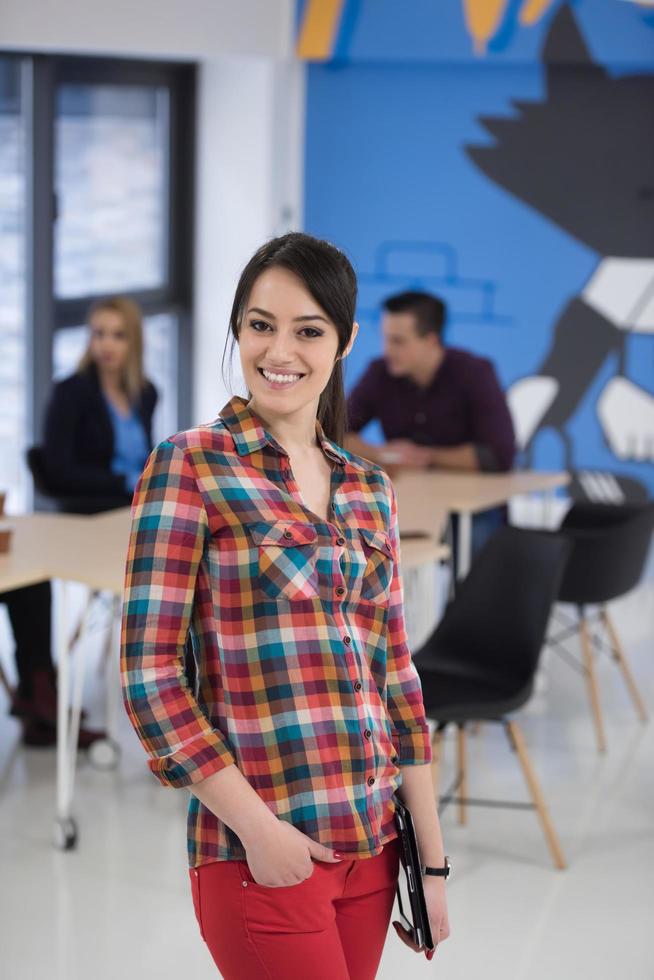 portrait of young business woman at office with team in background photo