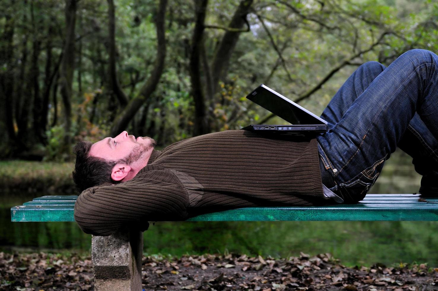 joven empresario trabajando en una laptop al aire libre foto