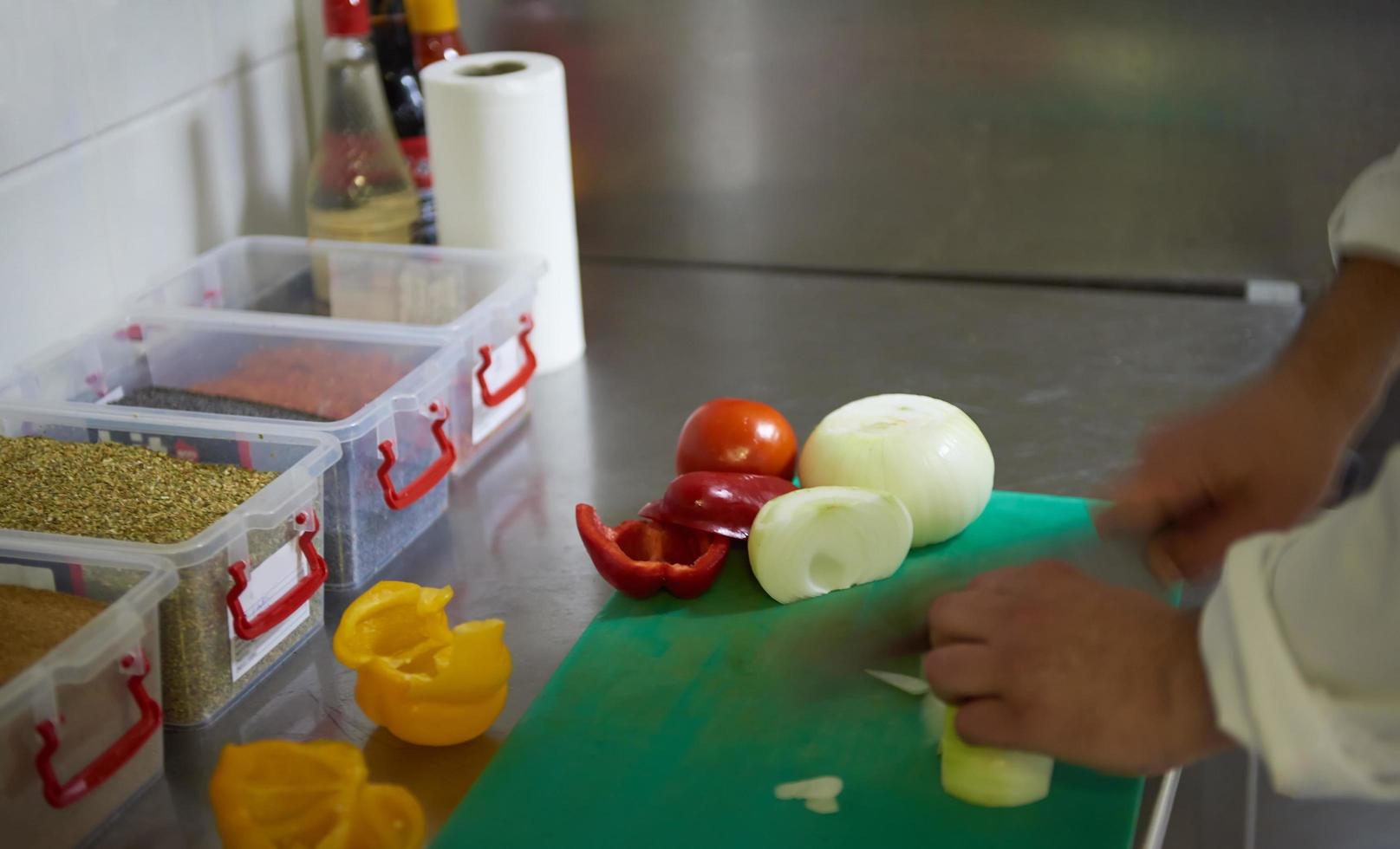 chef in hotel kitchen  slice  vegetables with knife photo