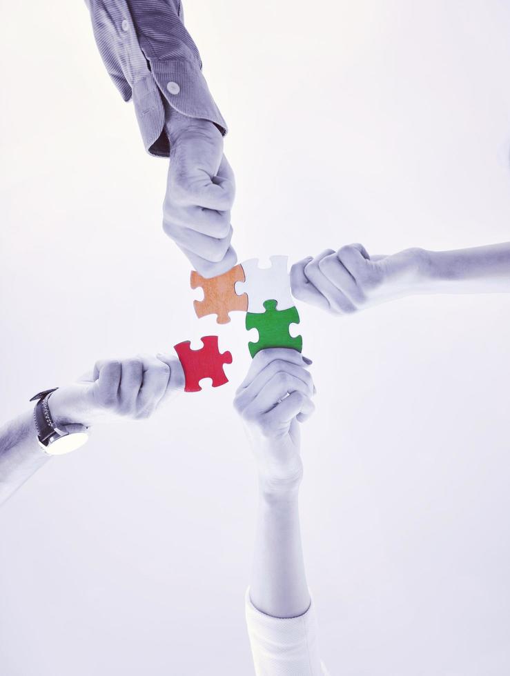 Group of business people assembling jigsaw puzzle photo