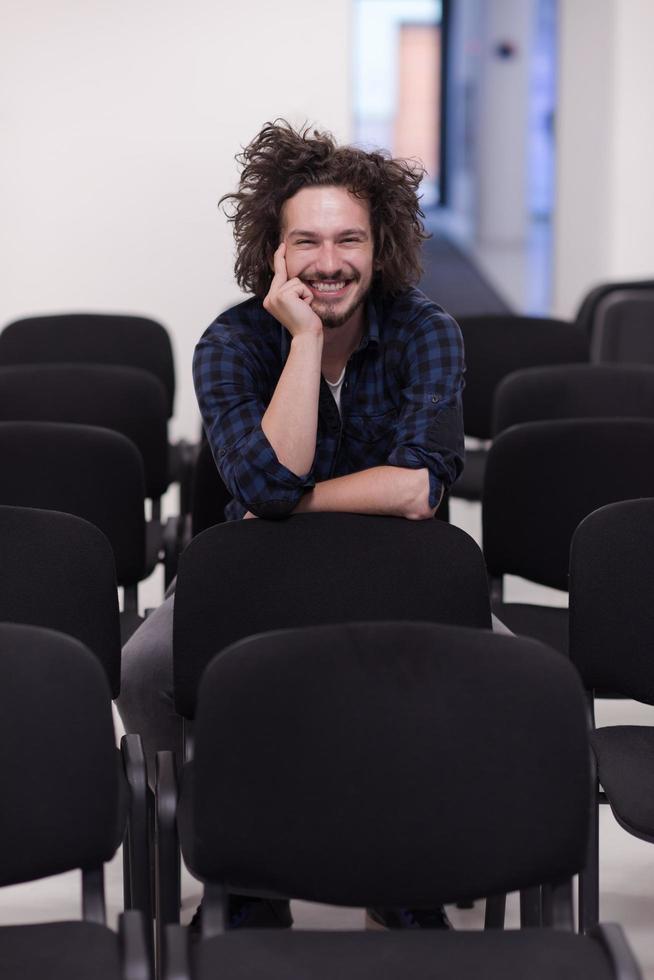 A student sits alone  in a classroom photo
