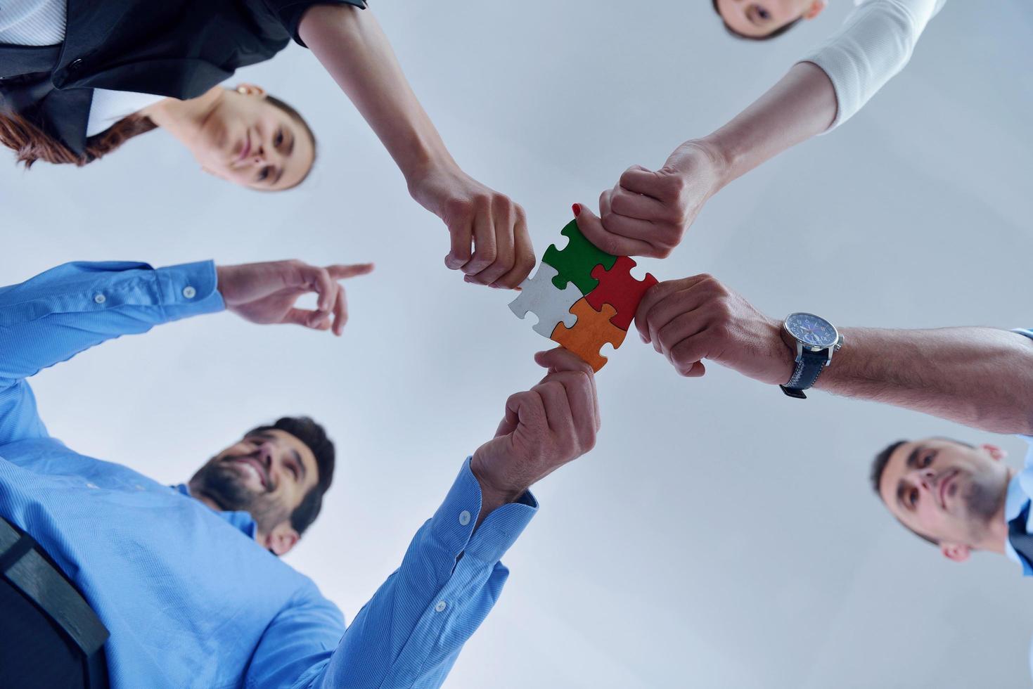 Group of business people assembling jigsaw puzzle photo