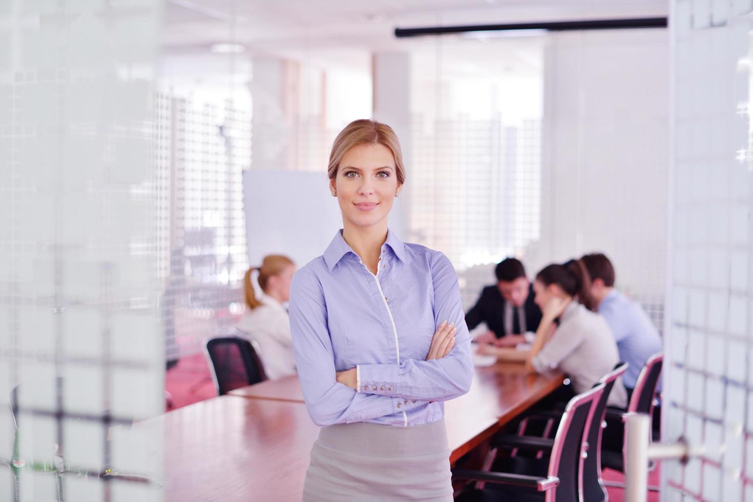 business woman with her staff in background at office photo