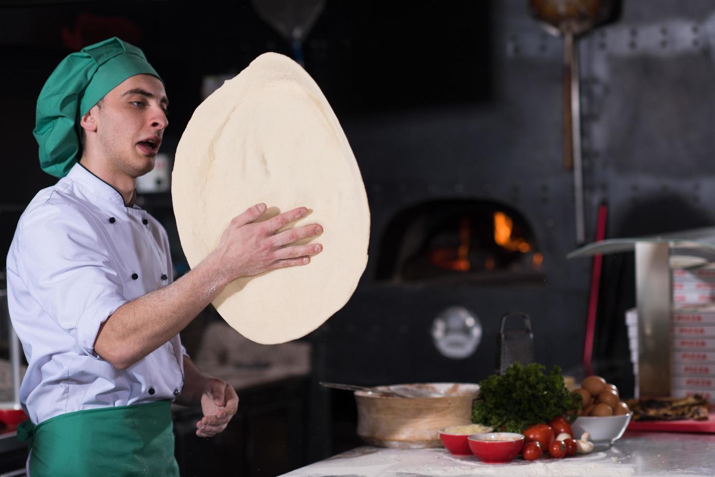 chef throwing up pizza dough photo