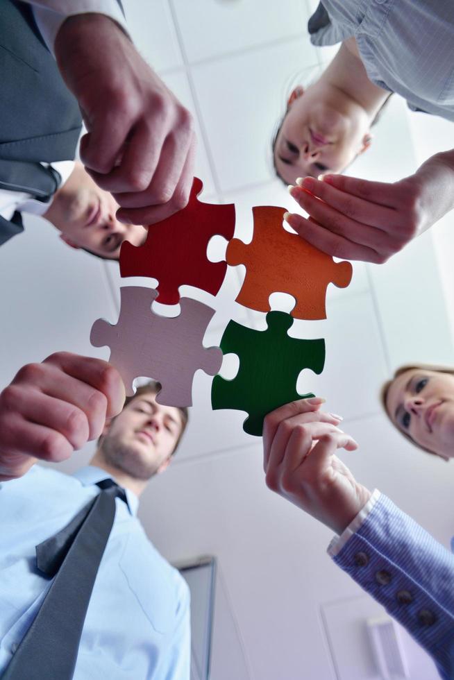 Group of business people assembling jigsaw puzzle photo