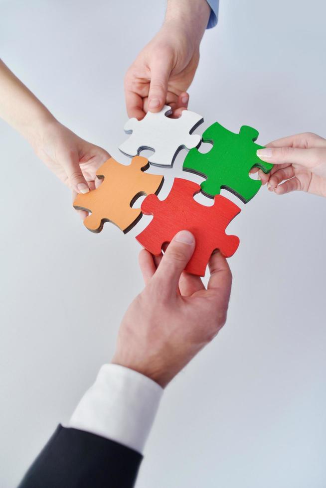 Group of business people assembling jigsaw puzzle photo