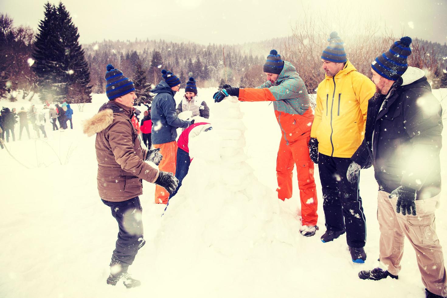 group of young people making a snowman photo