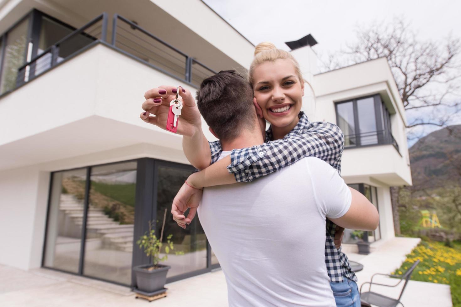 couple hugging in front of  new luxury home photo