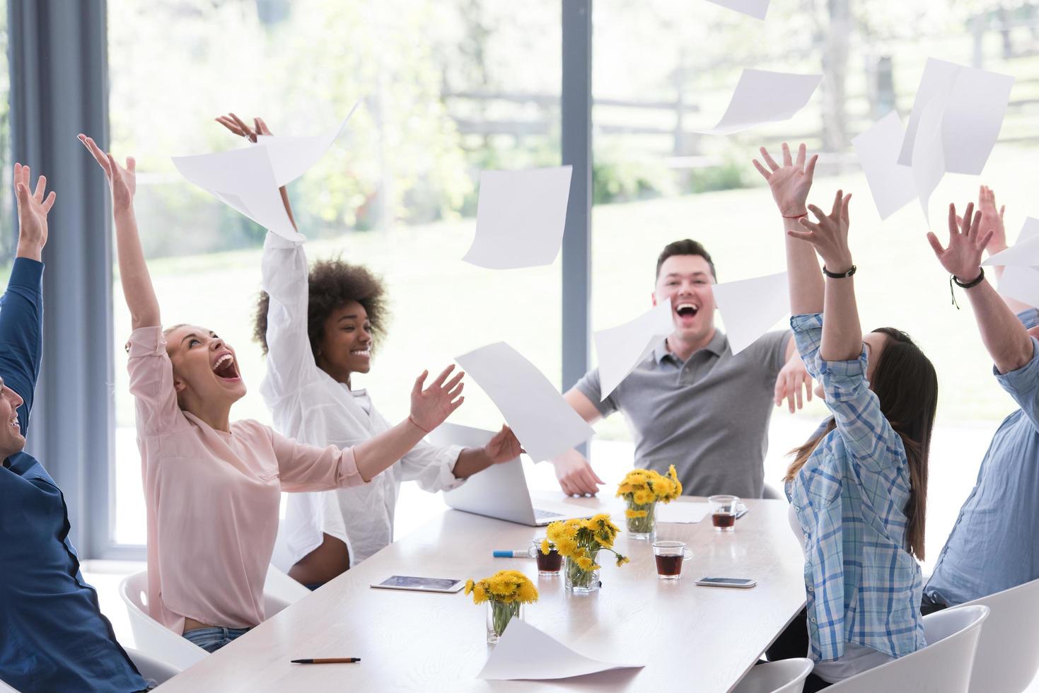 multiethnic startup Group of young business people throwing documents photo