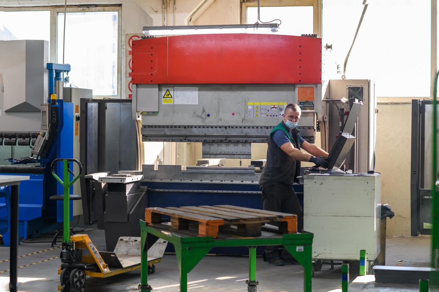 Turkey, 2022 - A smart factory worker or engineer wears a face mask because of a pandemic and makes machines in a production workshop. The concept of industry and engineering. photo