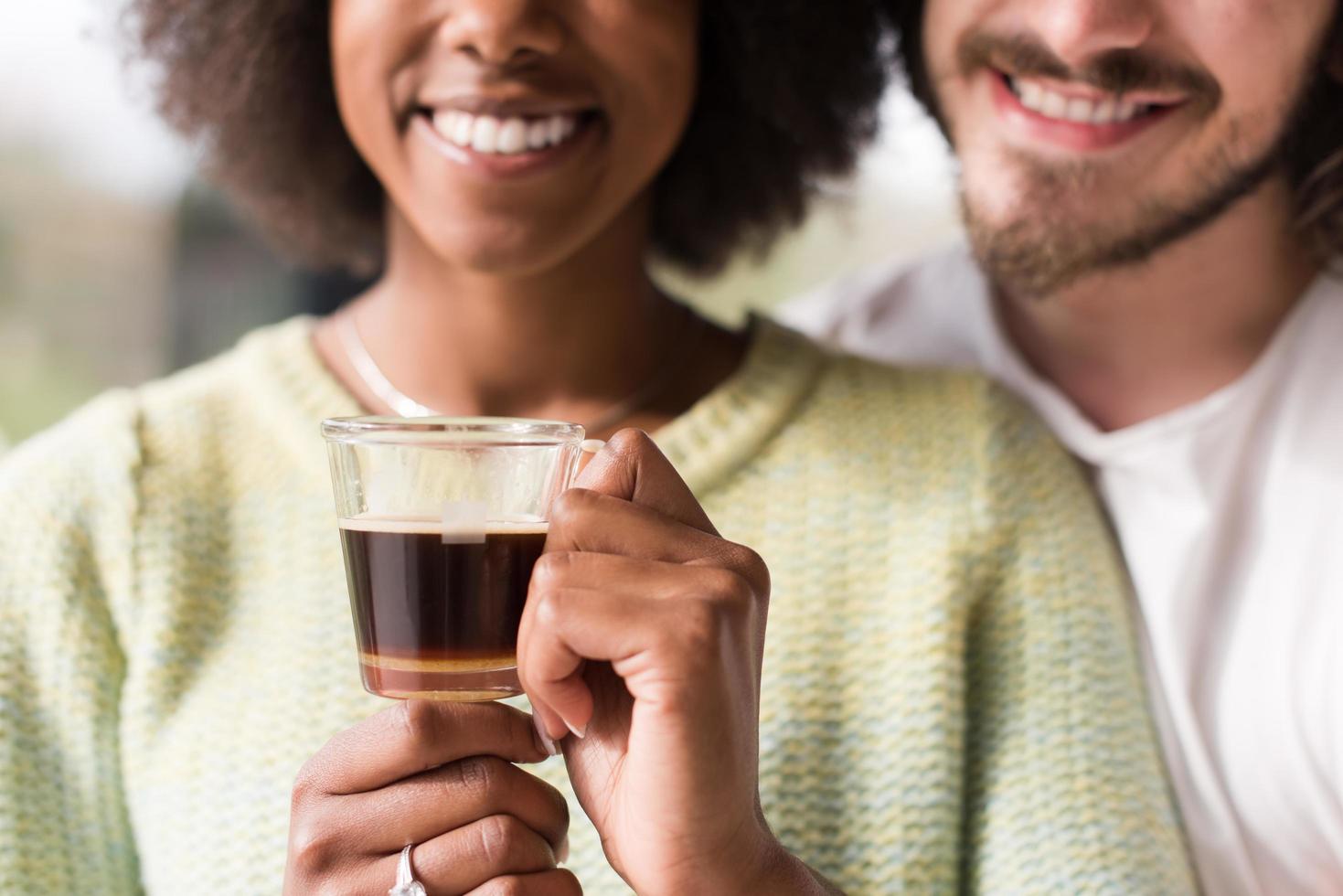 feliz pareja multiétnica relajándose en casa moderna en el interior foto