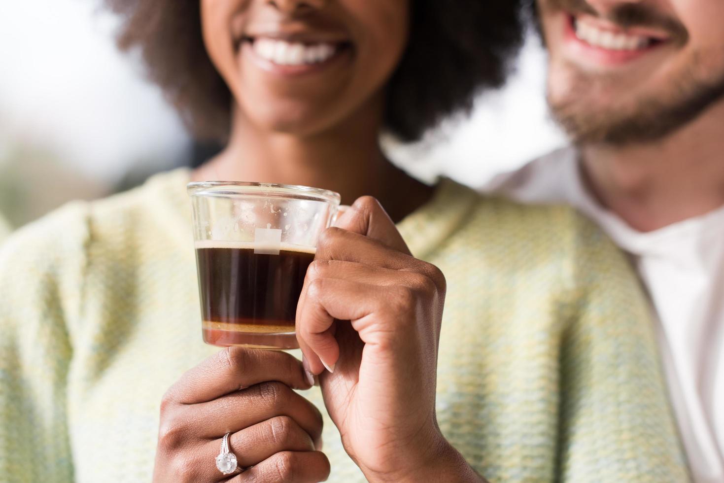 feliz pareja multiétnica relajándose en casa moderna en el interior foto