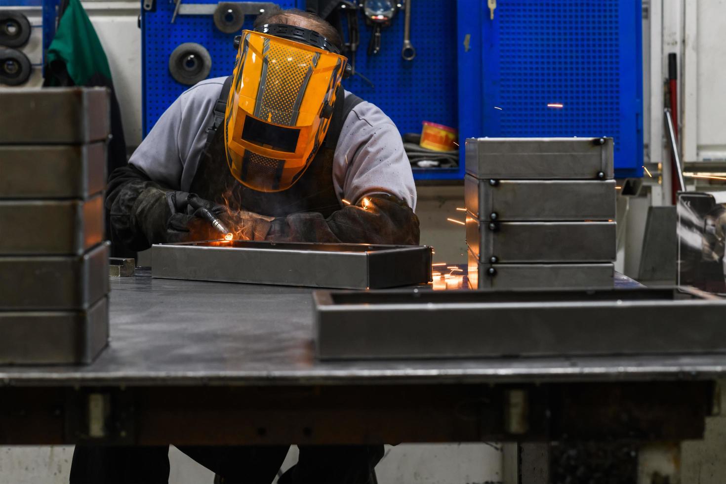 Professional welder performs work with metal parts in factory, sparks and electricity. Industry worker banner. photo