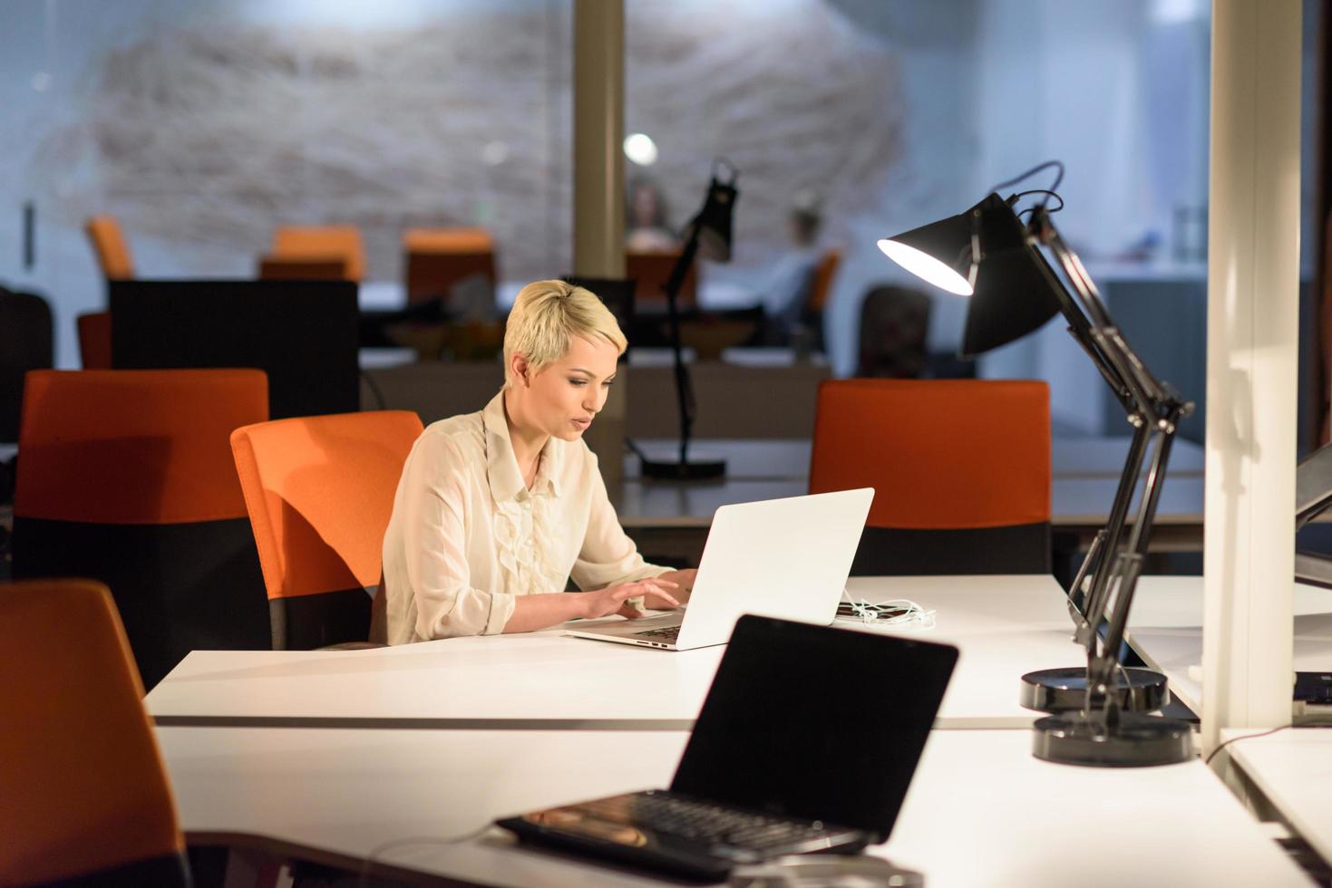 woman working on laptop in night startup office photo