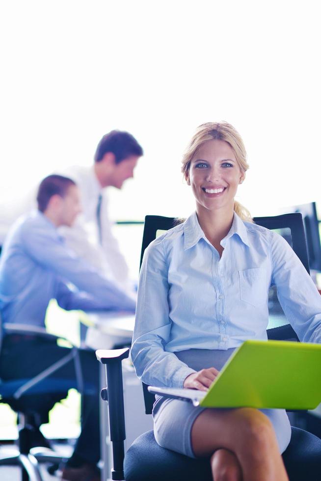 business woman with her staff in background at office photo