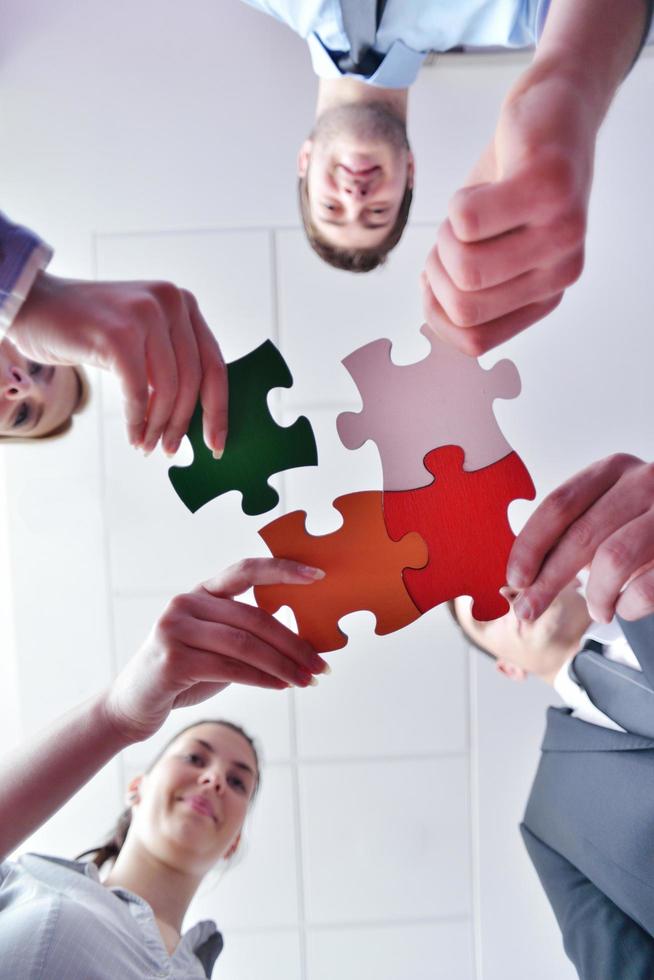 Group of business people assembling jigsaw puzzle photo