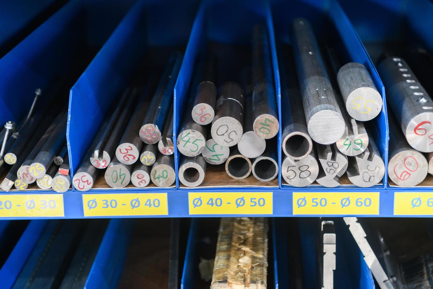 pipes, metal pieces and various metal parts for a CNC machine standing on a shelf photo