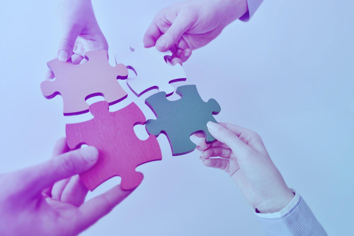 Group of business people assembling jigsaw puzzle photo