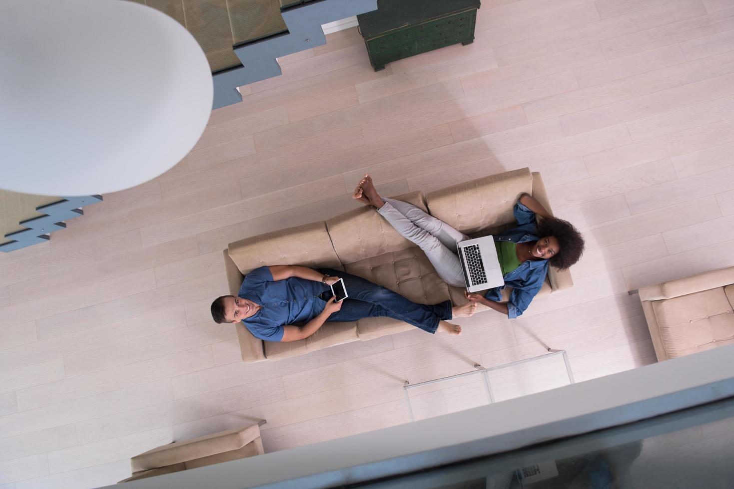 young multiethnic couple relaxes in the living room top view photo