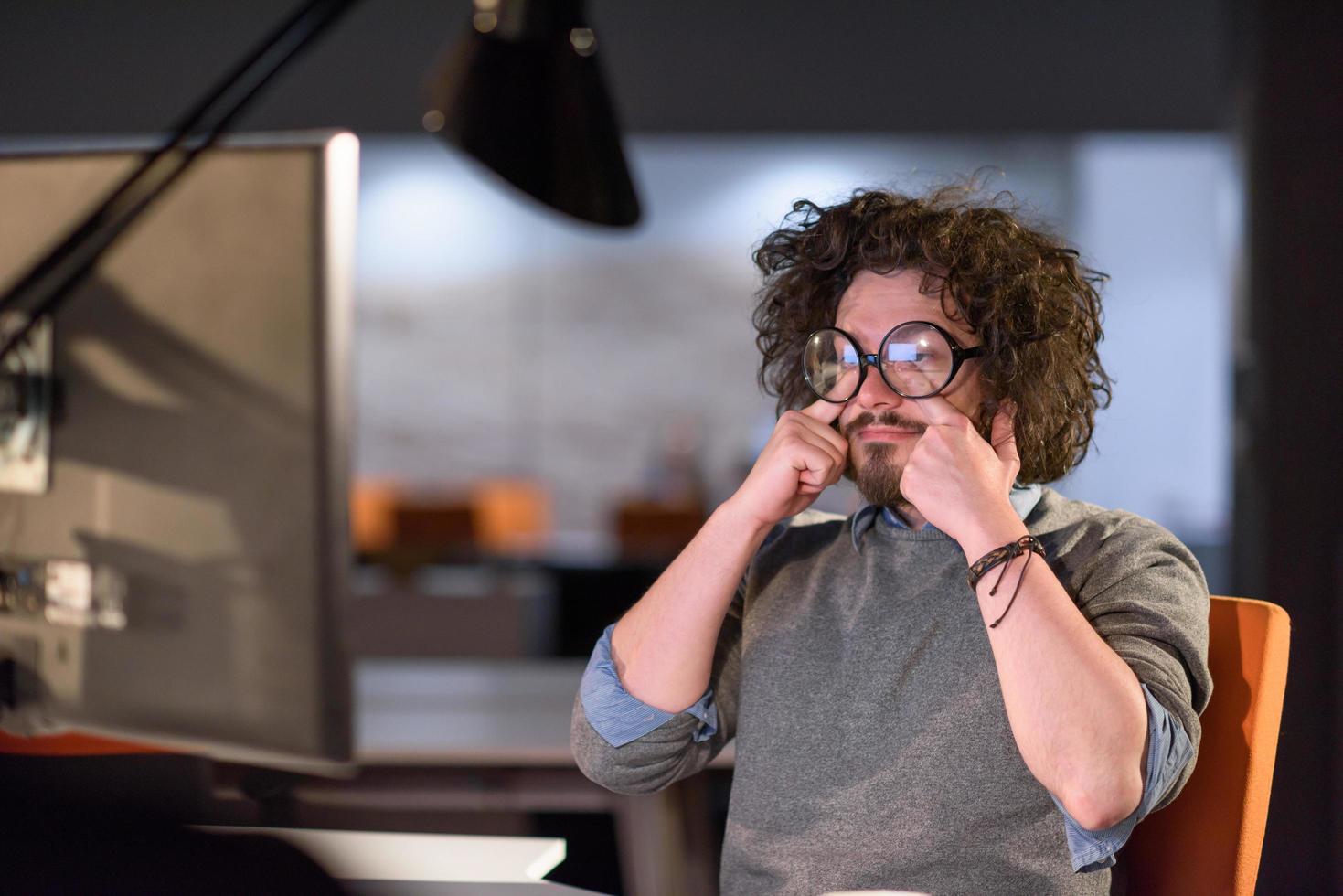 man working on computer in dark startup office photo