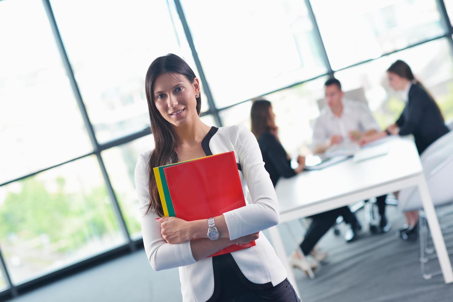 business woman with her staff in background at office photo