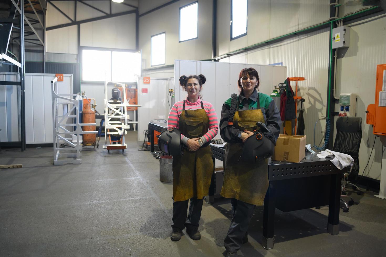 portrait of two welders holding welding masks in their hands and preparing for hard work in a factory photo