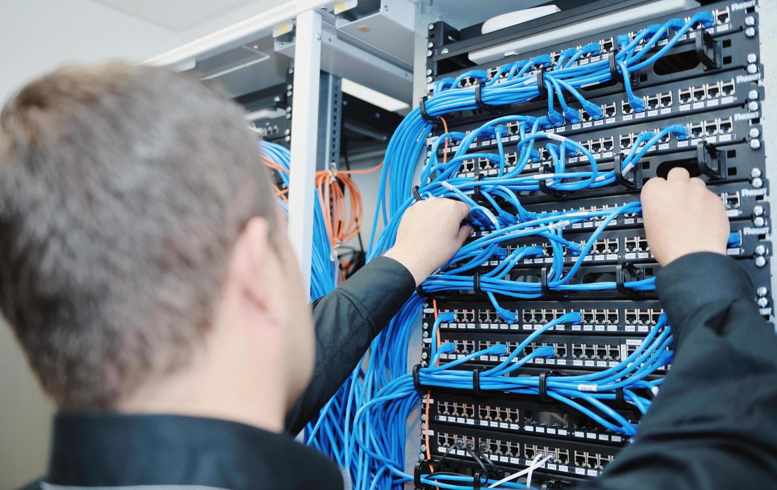 joven ingeniero informático en la sala de servidores del centro de datos foto