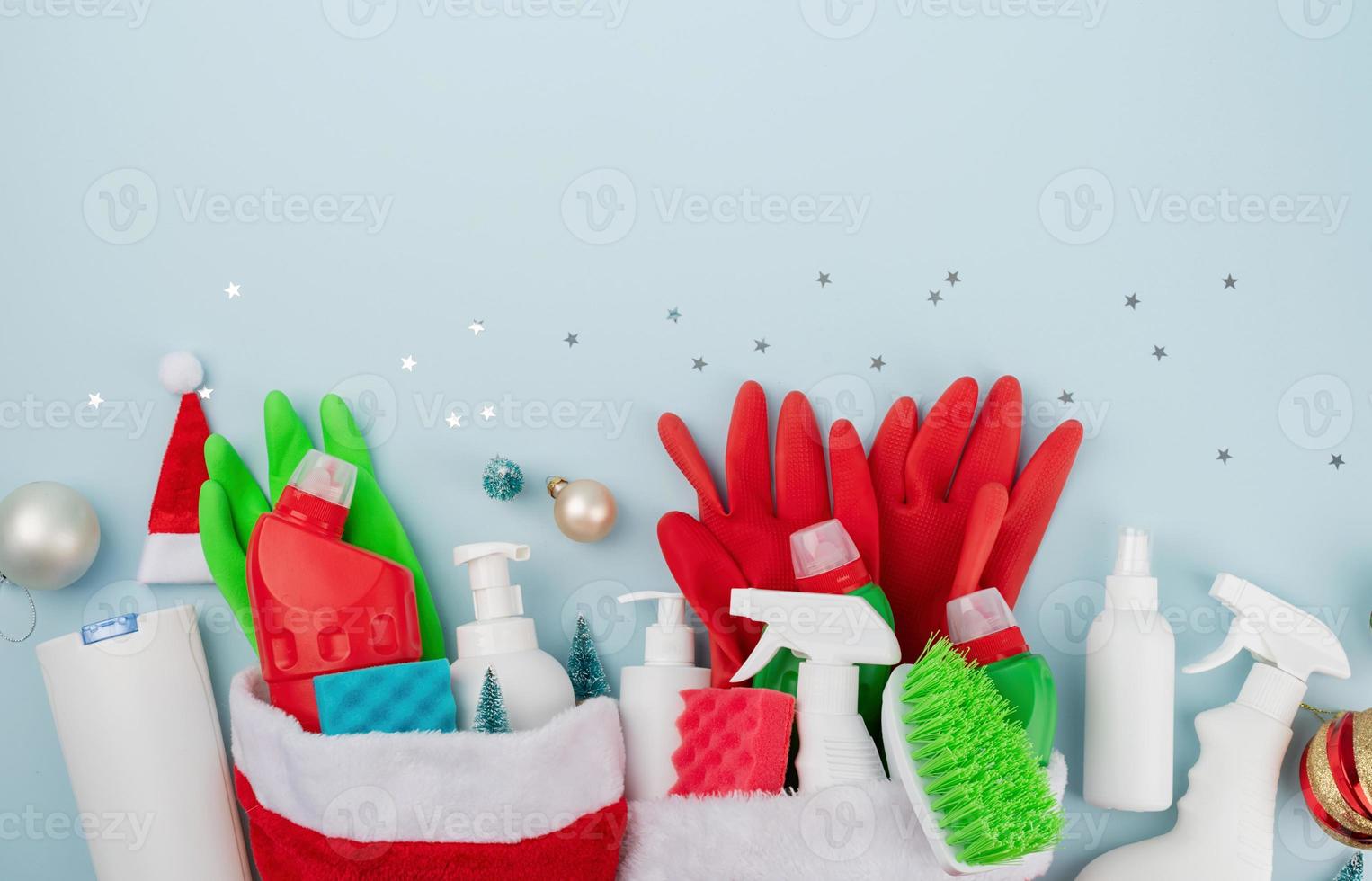 Christmas cleaning. Cleaning tools and Christmas decorations top view flat lay on blue background with copy space photo