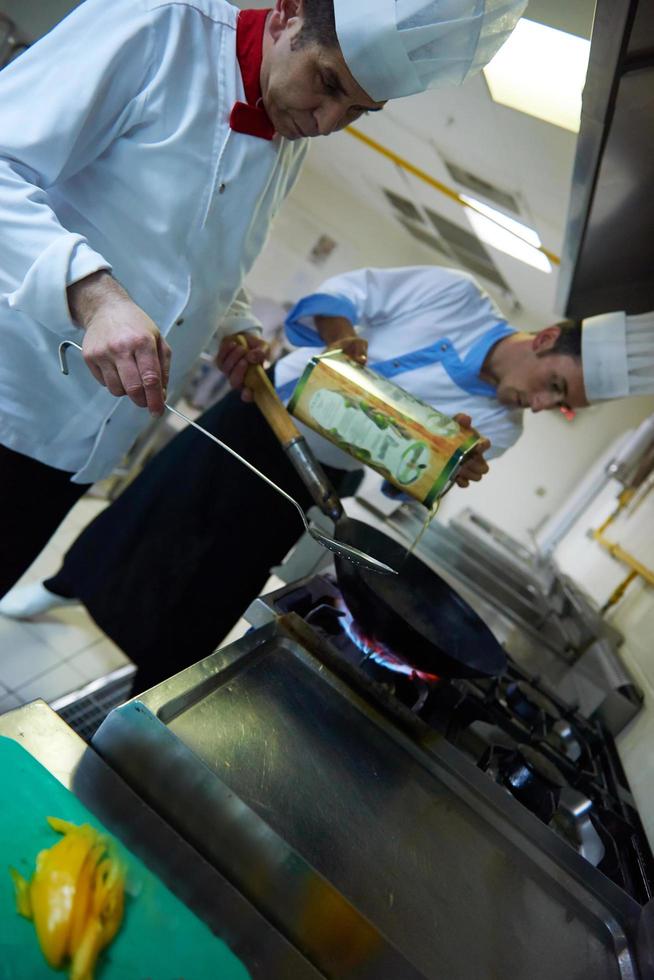 chef in hotel kitchen prepare food with fire photo