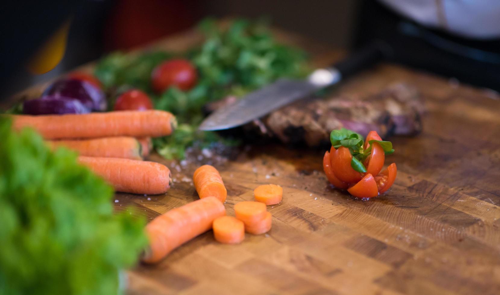 Juicy slices of grilled steak on wooden board photo