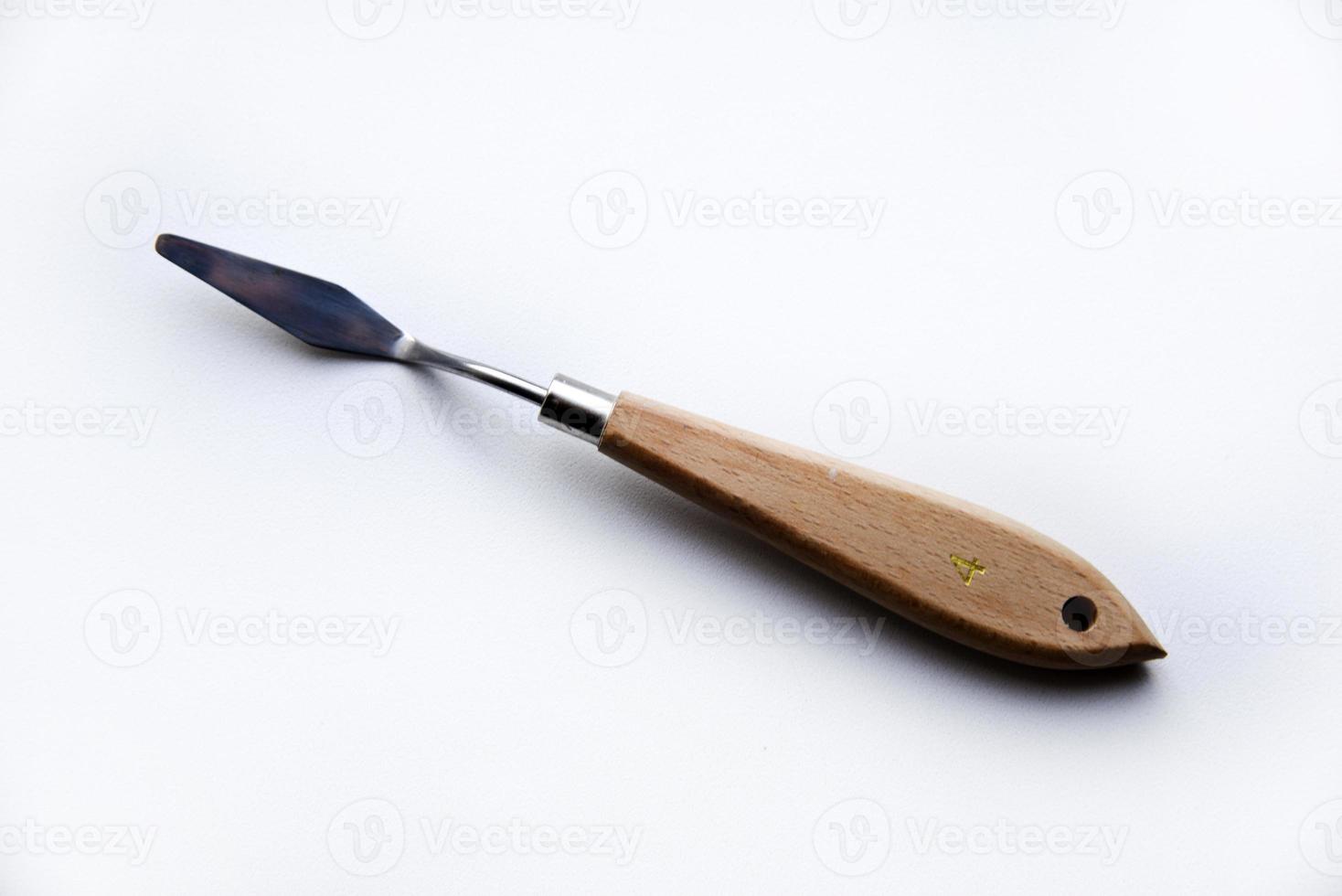 Palette knife No. 4 artistic iron with a wooden handle on a white background. An artist's paint tool. photo