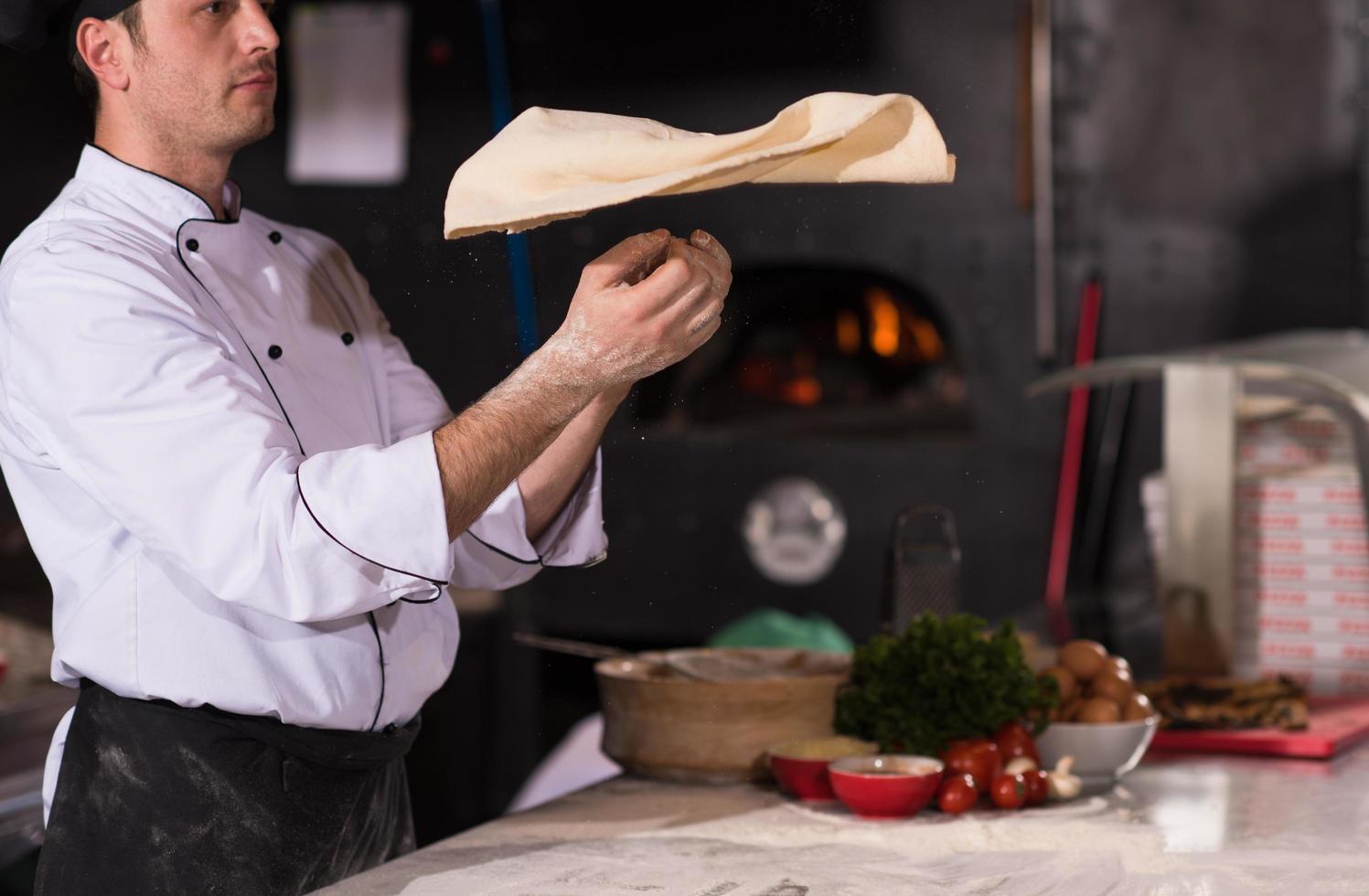 chef throwing up pizza dough photo