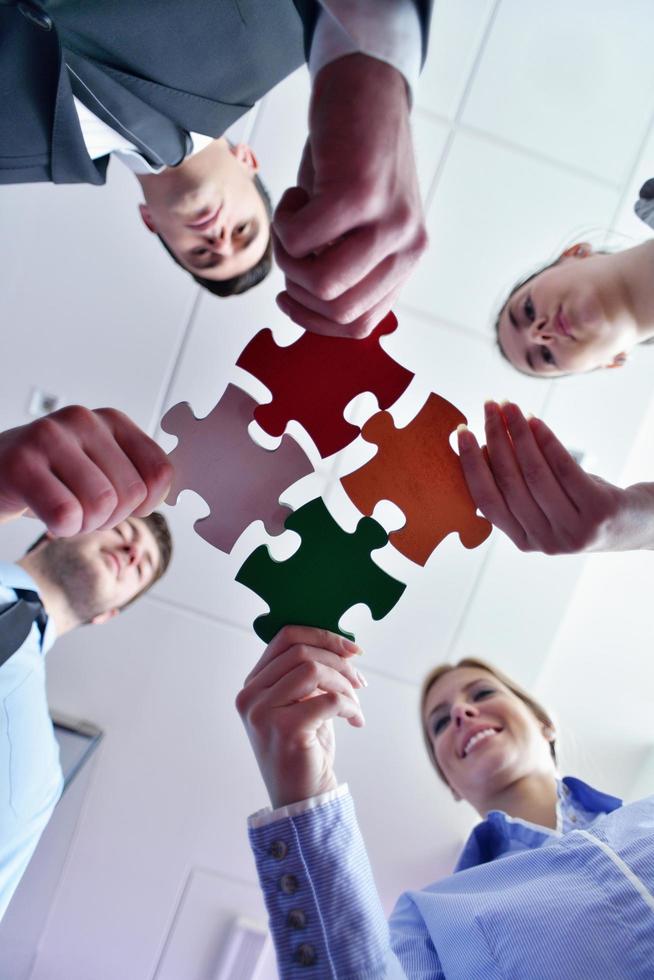 Group of business people assembling jigsaw puzzle photo
