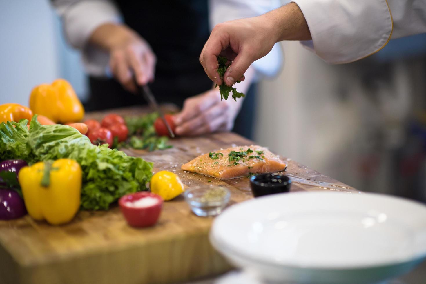 Chef hands preparing marinated Salmon fish photo