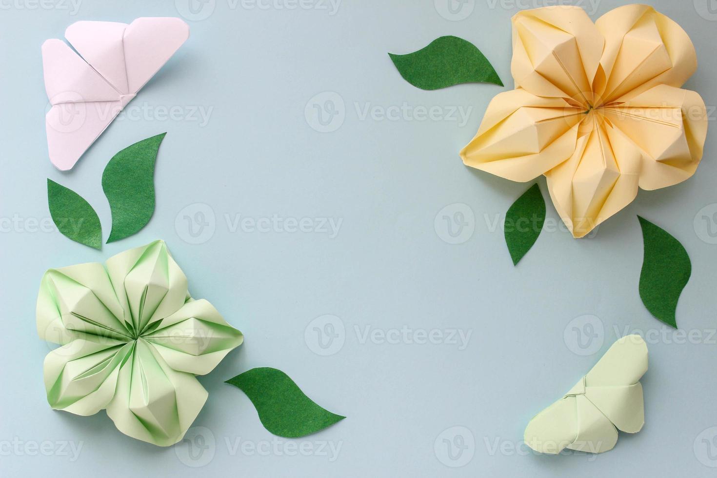 Origami paper background with butterflies, flowers and leaves. With place for text. Origami composition. Paper craft photo