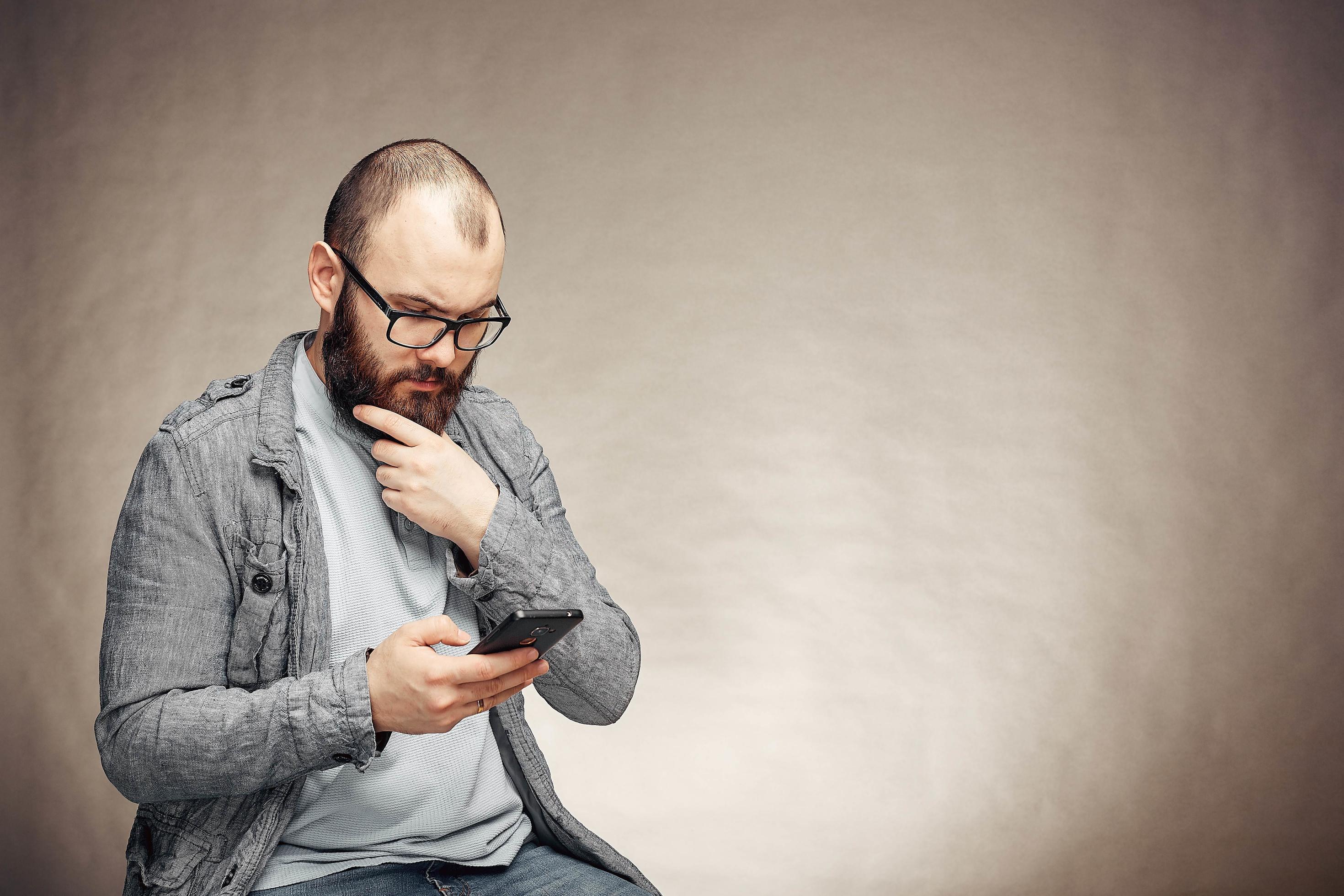 lifestyle brooding man with a beard and a telephone background lifestyle brooding man with a beard and a telephone background