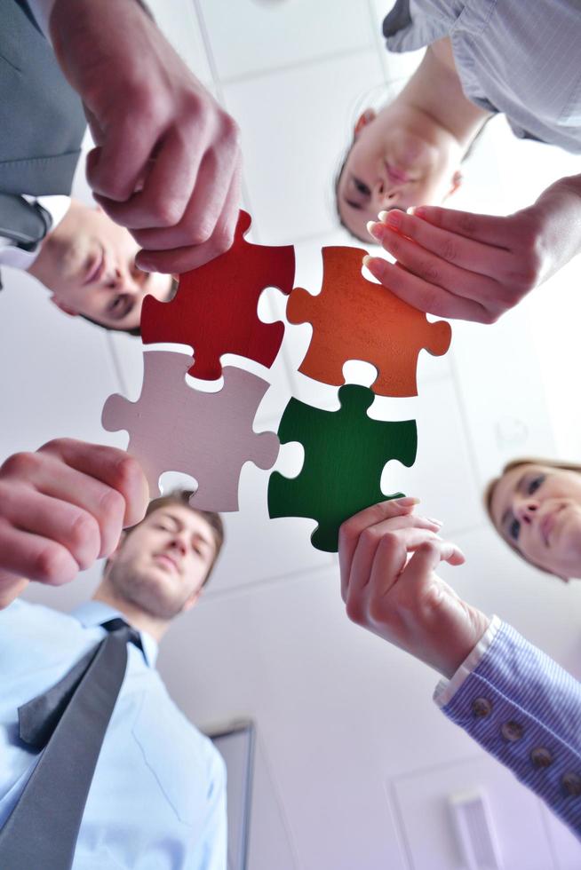 Group of business people assembling jigsaw puzzle photo