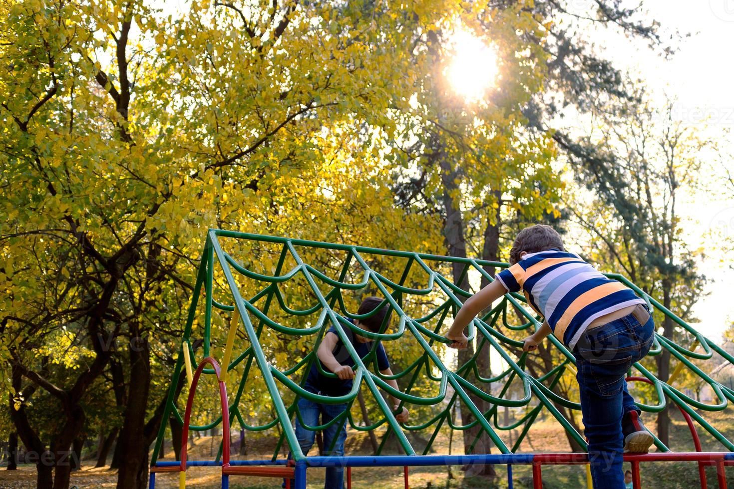 dos niños jugando en el patio de recreo en la naturaleza. foto
