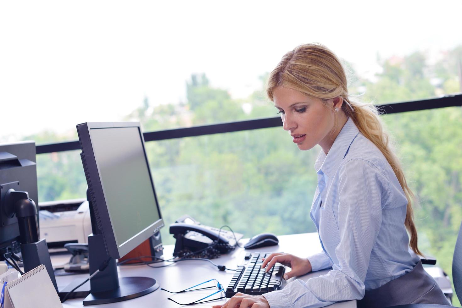 business woman working on her desk in an office photo