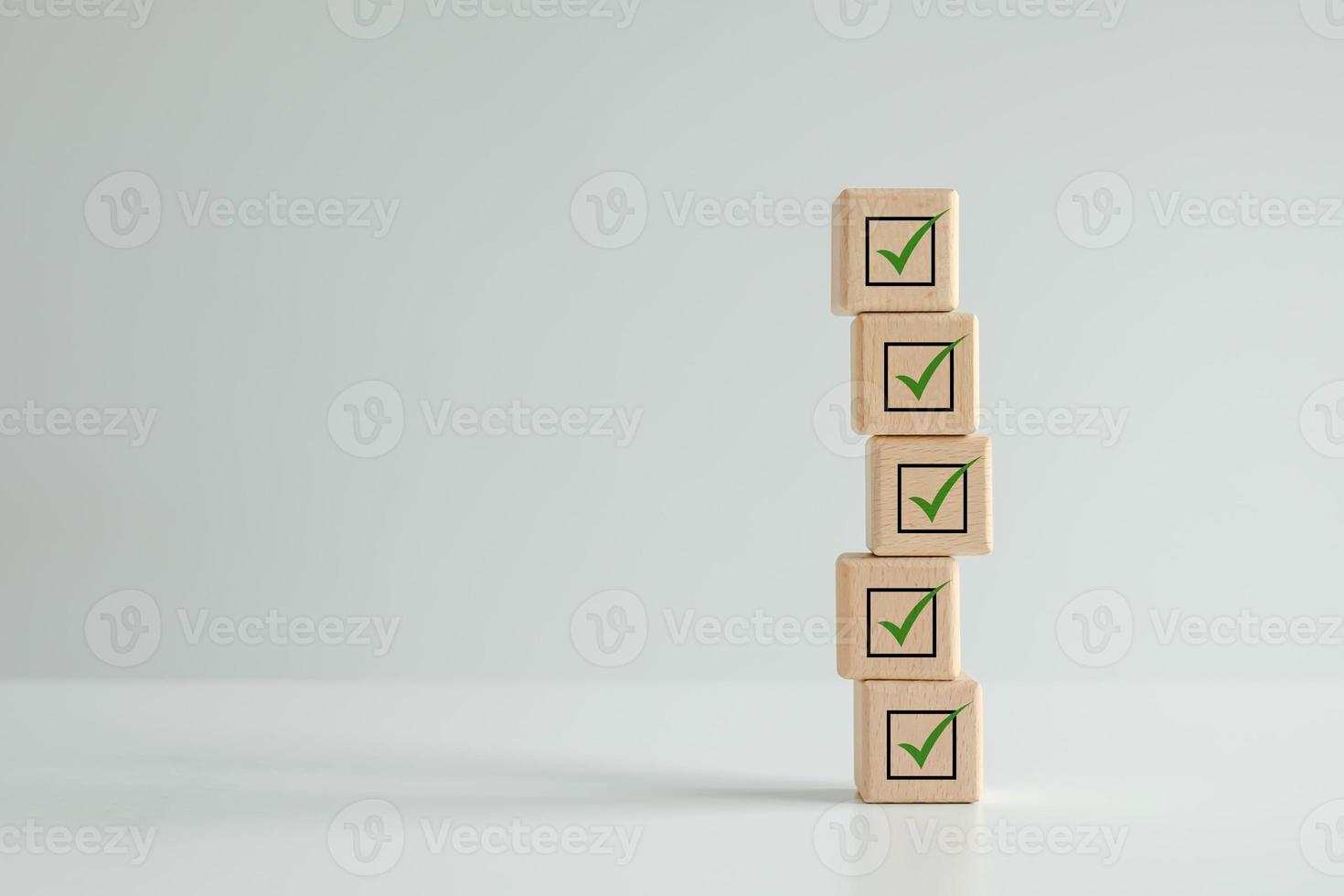 Checklist, Task list, Survey and assessment. Quality Control. Goals achievement and business success. Check mark icon on wooden blocks. photo