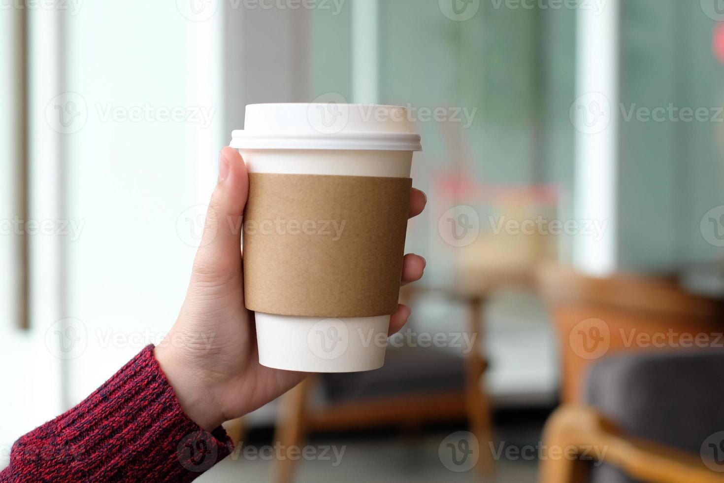 Close up of woman hand holding brown paper cup coffee . take away hot drinks. photo