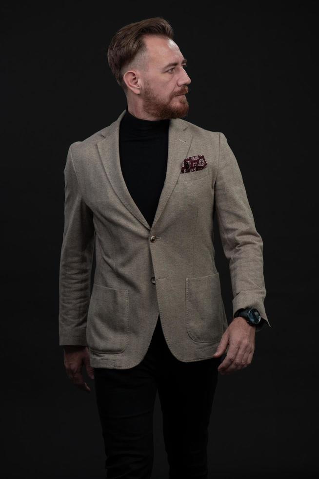 Confident businessman walking forward wearing a causal suit, handsome senior business man hero shot portrait isolated on black photo