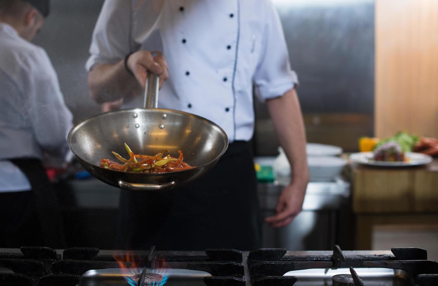 chef flipping vegetables in wok photo